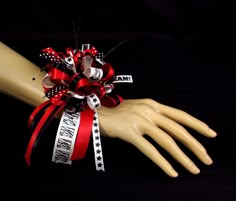 "This cheerleader wrist corsage could be for any occasion associated with sports. Maybe a sports banquet or a celebration of achievements. Whatever the occasion, this corsage is perfect for any cheerleader. There are many different ribbons included in this corsage including \"Cheer\" and \"Go Team!\", the megaphone in a 3-D button as well as in ribbon. Also in this corsage are sprays of mini black bead strings. Since the worded ribbon is white, there will be white in all corsages. If a boutonnie Wrist Mums Homecoming, Cheer Senior Night Gifts, Graduation Corsage, Georgia Bulldog Wreath, Unique Homecoming Mums, Hoco Mums, Texas Mums, Homecoming Mums Senior, Homecoming Flowers