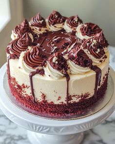 a cake with white frosting and chocolate swirls on top sitting on a plate