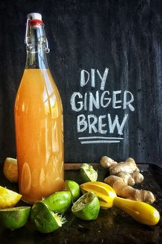 a bottle of ginger beer surrounded by lemons and limes