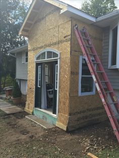 a house being built with the ladder up to it's door and window frame