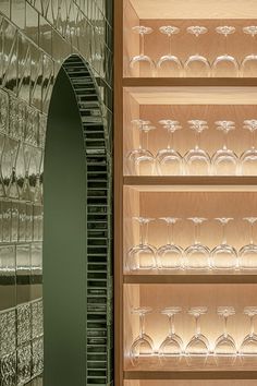 the wine glasses are lined up on the shelves