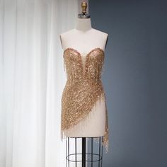 5-7 weeks processing and shipping time This design is from the Bellezza collection. Looking for a dress to make a statement? This copper/gold sequin and tassel mini dress is perfect! This dress is perfect for a birthday party, clubbing, night out or any glamorous occasion.Color may vary due to lighting Material: rhinestones, mesh, polyester Care: hand wash or dry clean only Glamorous Sleeveless Mini Dress With Tassels, Mini Length Beaded Fringe Dress For Party Season, Sleeveless Tassel Mini Dress For Party, Sleeveless Mini Dress With Tassels For Party, Mini Flapper Dress With Fringe For Party Season, Mini Dress With Rhinestone Fringe For Club Party, Beaded Fringe Party Dress For Prom Season, Glamorous Beaded Fringe Mini Dress For Night Out, Mini Dress With Rhinestone Fringe For Club