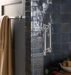 a bathroom with a glass shower door and towel rack