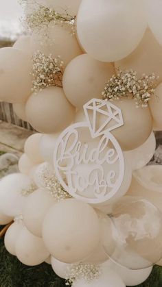 white balloons with the words bride to be cut out on them and surrounded by flowers