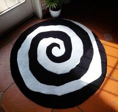 a black and white rug on the floor next to a potted plant