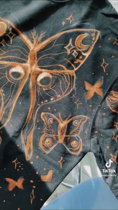 a close up of a shirt with a butterfly on it's chest and stars around the neck