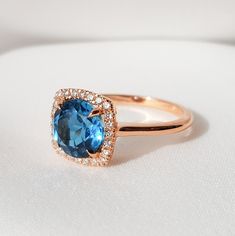 "London Blue Topaz Engagement Ring, Blue Topaz Halo Ring, December Birthstone Ring, London Blue Topaz Ring Round Cut 8mm A round London Blue Topaz surrounded by 24 diamonds in a cushion shape halo. A really distinctive luxury ring, perfect choice for an engagement ring. Item Details ❤ Made to Order ✔ Available Gold Color: Rose Gold, Yellow Gold, White Gold ✔ Number of Blue Topaz: 1, Diameter 8mm, total CTW:2.85 Ctw ✔ Number of Diamonds: 24, total CTW: 0.17 Ctw ✔ Diamond Color-Clarity: G Color, V Blue Topaz Cushion Cut Ring With Halo Setting, Cushion Cut Blue Topaz Ring With Halo Setting, Round Cut Topaz Ring With Gemstone Accents, Blue Topaz Diamond Ring With Gemstone Accents, Blue Topaz Ring With Gemstone Accents, Fine Jewelry Blue Topaz Ring With Halo Setting, Blue Topaz Halo Ring As Gift, Blue Topaz Rings With Gemstone Accents, Blue Topaz Ring With Sapphire Color And Halo Setting