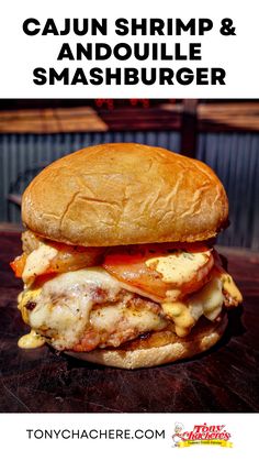 a close up of a sandwich on a table with the words cajun shrimp & andoulie smashburger