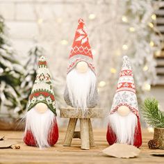 three christmas gnomes sitting on top of a wooden bench