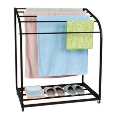 three pairs of shoes and two towels on a black rack with four different colored towels