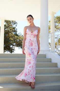 The Vivienne Maxi Dress is a stunning, full-length dress in soft floral print, designed to accentuate your silhouette with a form-fitting bodice and a relaxed flow towards the hem. The dress features a plunging neckline and delicate spaghetti straps that crisscross in the back for an elegant, yet flirty look. Ideal for summer weddings, date nights, or vacation evenings. LS254 Spring Wedding Guest, Spring Wedding Guest Dress, Wool Winter Coat, The Vivienne, Essential Dress, 21st Dresses, White Dress Party, Winter Pants, Date Nights