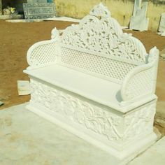 a white bench sitting on top of a cement slab