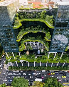 an aerial view of a city with lots of trees and plants growing on the buildings