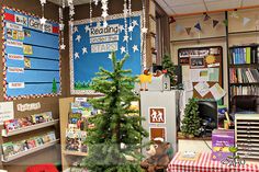 there is a christmas tree in the middle of this classroom with decorations on the walls