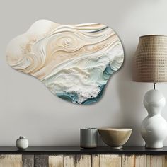 a wall mounted art piece on the side of a wooden table next to a lamp