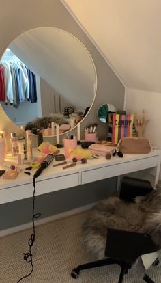 a dressing table with various items on it and a large round mirror in the corner