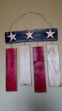 three wooden stars hanging from the side of a wall next to a red white and blue flag