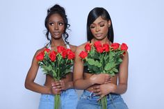 two beautiful young women holding roses in their hands