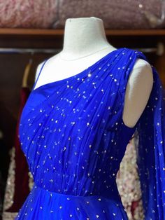 This sparkle blue milky way one-shoulder gown with heavy embellishments with sequin and swaroski work is a contemporary pick with golden sequence border design. Make an grand entry on your special day in this beautiful gown. Fabric: Net Size: 38/M Ready to Ship! Sparkling Blue Evening Dress For Wedding, Glamorous Blue Wedding Gown, Royal Blue Sequin Gown For Wedding, Glamorous Blue Embellished Gown, Blue Embellished Party Gown, Blue Embellished Gown For Party, Blue Embellished Party Wear Gown, Blue Sequined Wedding Gown, Blue Embellished Dress For Reception