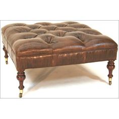 a brown leather ottoman sitting on top of a white floor