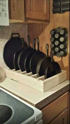 pots and pans are sitting in a holder on the counter top next to an oven