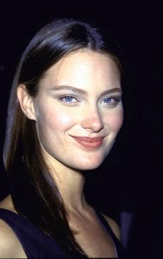 a woman with long hair smiling at the camera