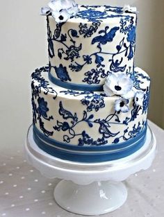 a three tiered cake with blue and white designs