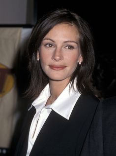 a woman wearing a black suit and white shirt