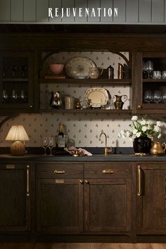 a kitchen with wooden cabinets and black counter tops, gold trimmings on the wall