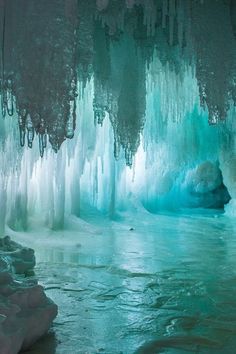 an ice cave filled with water and icicles