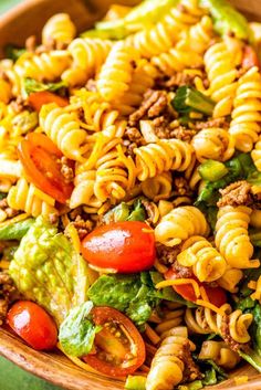 a bowl filled with pasta salad on top of a green table