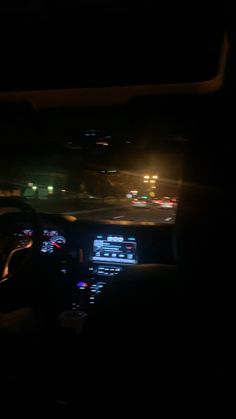 the interior of a car at night with lights on and dash lights in the background