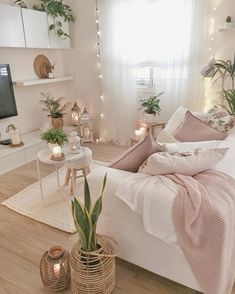 a living room filled with lots of furniture and plants on top of the couches