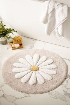 a white bath mat with a flower on it