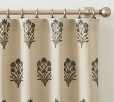 a beige curtain with black flowers on it