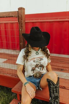 Showcase your state pride with our Championship State Roundup Graphic Tee! This tee features a cowgirl on horseback graphics. Whether you're a rodeo enthusiast or simply love the Western aesthetic, the Championship State Roundup Graphic Tee is sure to keep the eyes on you. Unisex fit Made in the USA Western Style T-shirt For Rodeo, Country Style T-shirt For Rodeo In Fall, Western Rodeo Tops With Letter Print, Western Style Rodeo Tops With Letter Print, Western Style Letter Print Tops For Rodeo, Western Style Rodeo Top With Letter Print, Western Style T-shirt For Fall Western-themed Events, Western-style T-shirt For Western-themed Fall Events, Ranch Photography