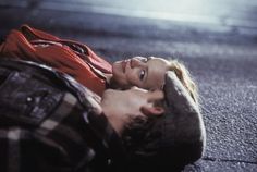 a young woman laying on the ground with her head in her hands and looking up