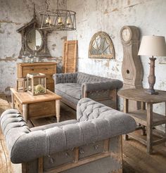 a living room filled with lots of furniture next to a wooden table and mirror on the wall