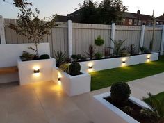 an outdoor garden with white planters and lights