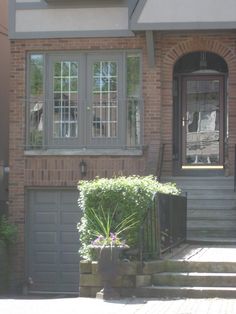 a brick house with two garages and steps leading to the front door