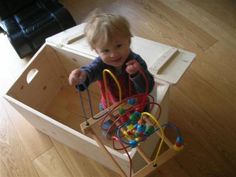 a toddler in a box playing with toys