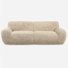 a white couch sitting on top of a carpet covered floor next to a gray wall