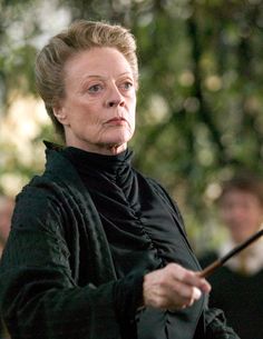 an older woman holding a wand in her right hand and looking off to the side