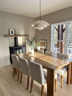 a dining room table with four chairs and a fire place in the back ground area