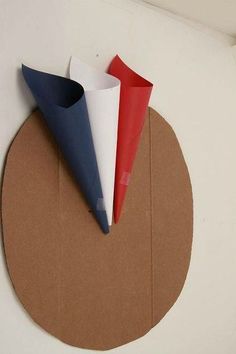 there are four different colored paper cones on the circle wall hanging in front of it