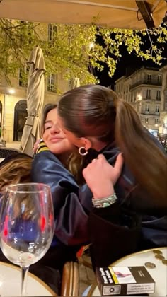 two women hugging each other at an outdoor restaurant