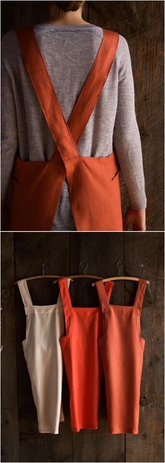 the back of an orange and white dress hanging on a clothes rack with three different colors