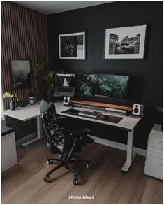 a home office with black walls and white desks, two framed pictures on the wall