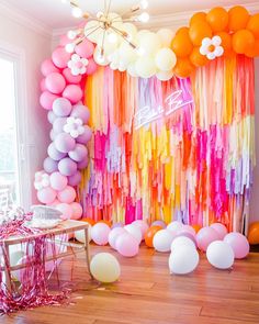 a room filled with balloons and streamers on the wall next to a wooden floor