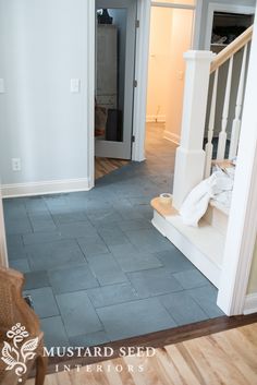 an empty room with stairs leading to the second floor and another door in the background